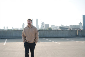 Man wearing Barbell Foundation Hoodie with City backdrop