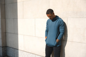 Man wearing Barbell Stealth Hoodie leaning against a wall