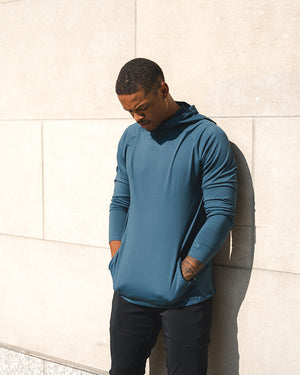 Man wearing Barbell Stealth Hoodie leaning against a wall
