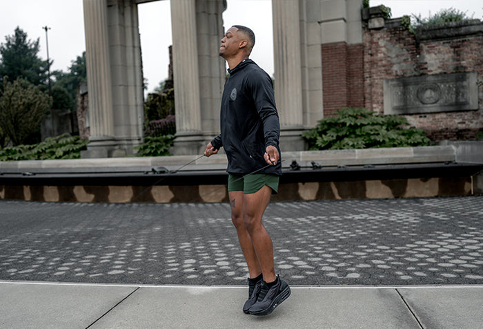 Man in Barbell athletic wear standing on a stone pathway with classical architecture in the background