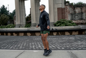 Man in Barbell athletic wear standing on a stone pathway with classical architecture in the background