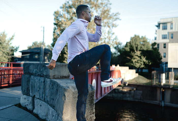 man outside in dress shirt and jeans on waterway